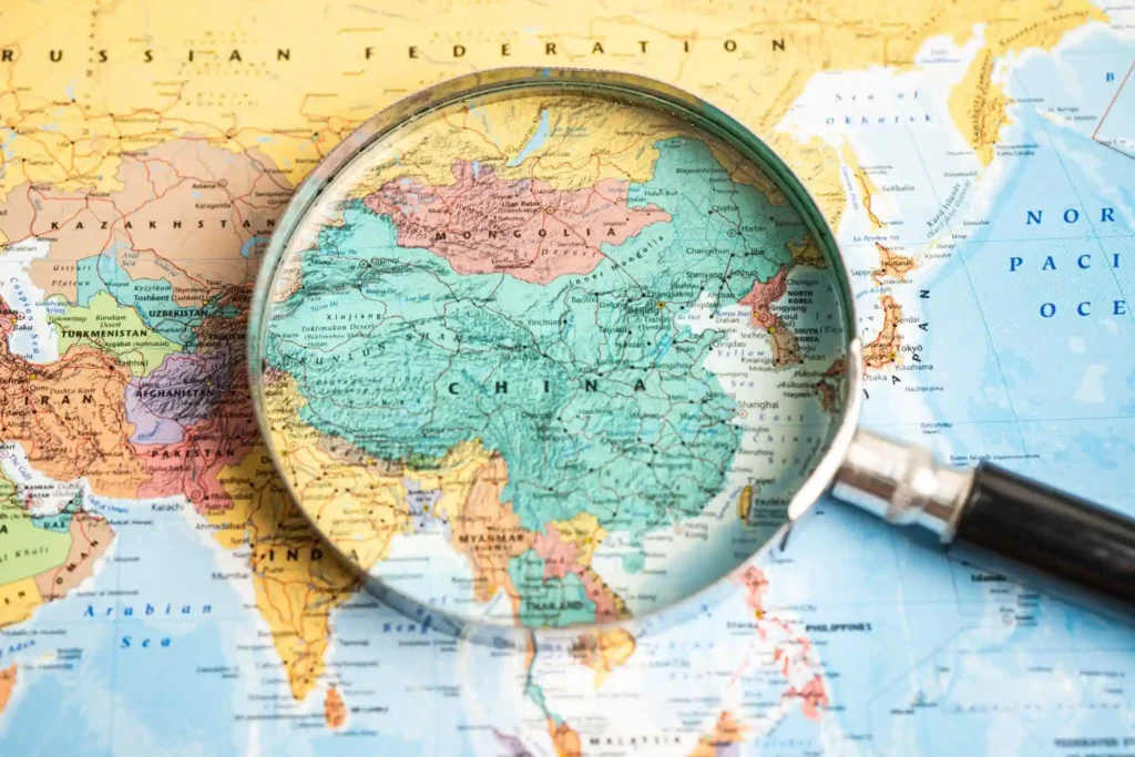 Una lupa enfocando el mapa de China para analizar importaciones y exportaciones legales hacia España