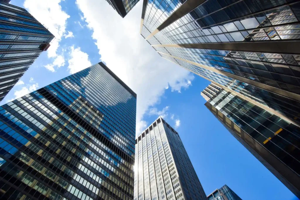 Rascacielos de cristal modernos bajo un cielo azul para ilustrar operaciones inmobiliarias entre China y España.
