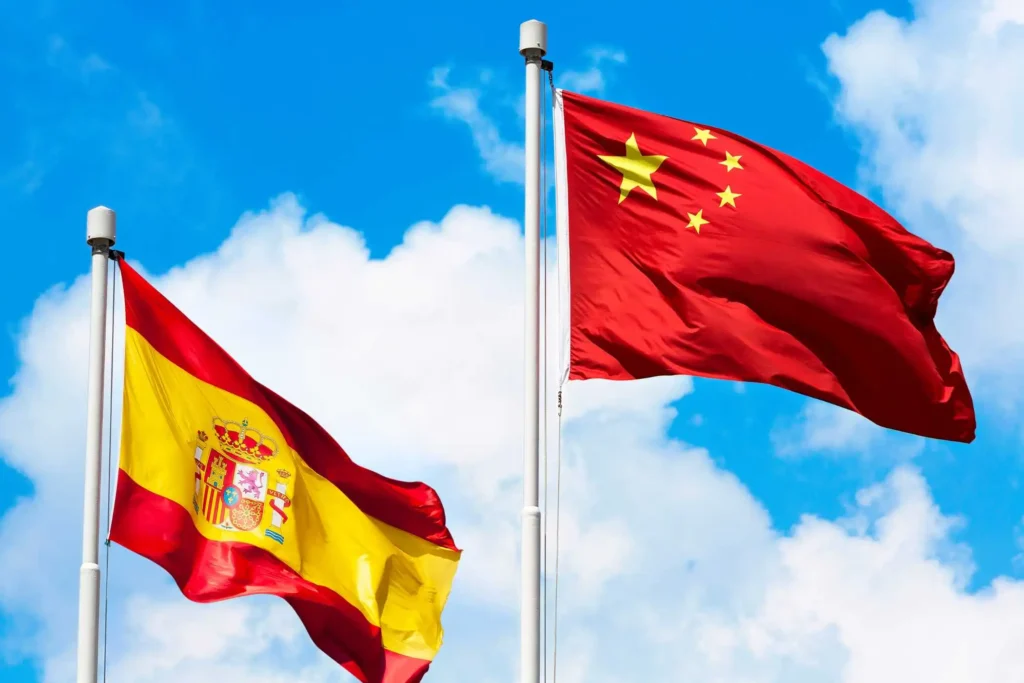 Banderas de España y China ondeando para ilustrar la prevención de blanqueo de capitales en movimientos de fondos.