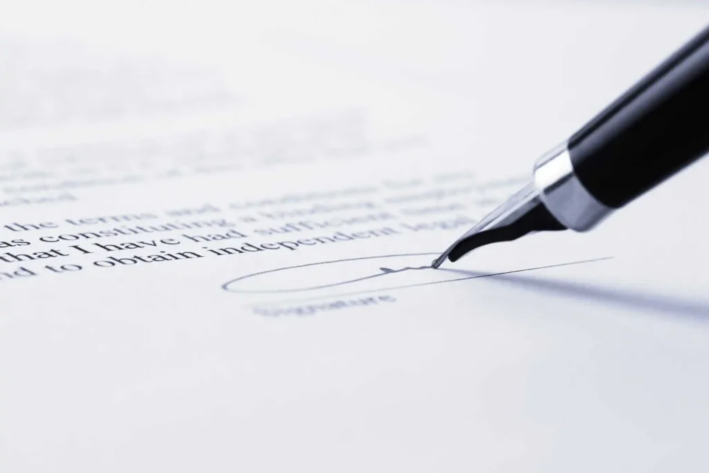 Pluma estilográfica firmando un documento legal para identificar al titular real de sociedades chinas.