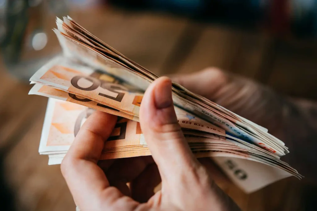 Manos contando billetes de 50 euros para justificar transferencias internacionales entre China y España.