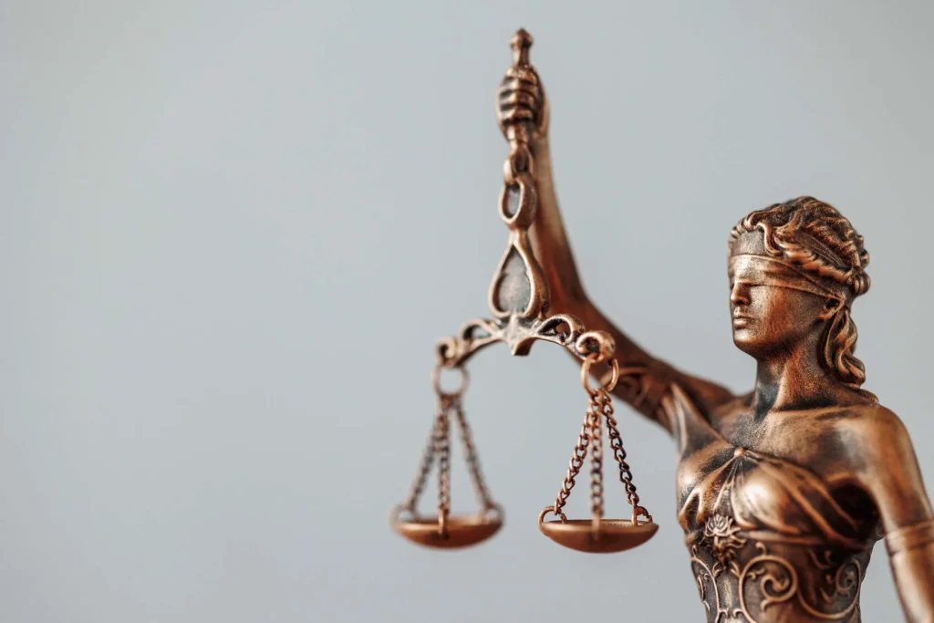 Primer plano de la estatua de la Dama de la Justicia sosteniendo la balanza en el bufete Capitalea.